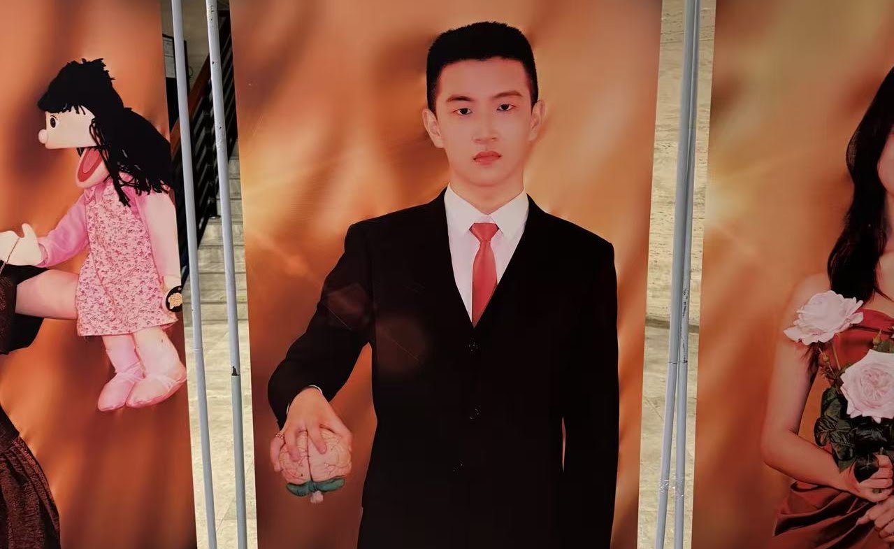 Chris Wan in a suit with a red tie, dressed as Patrick Bateman for a solo musical theatre piece